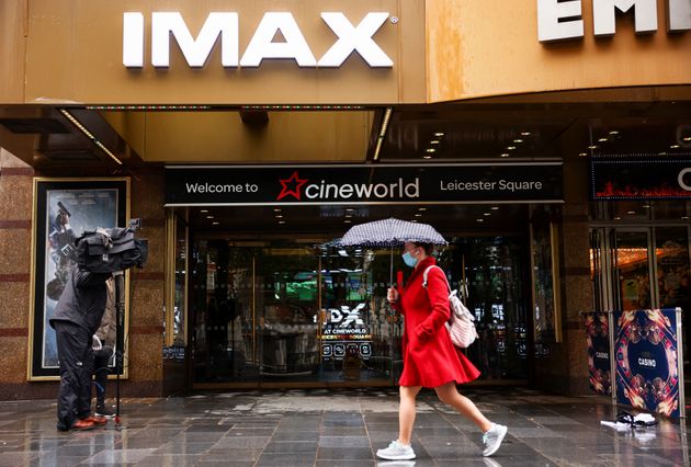 A woman holds an umbrella as she walks past a Cineworld in Leicester's Square, amid the coronavirus disease (COVID-19) outbreak in London, Britain, October 4, 2020. REUTERS/Henry Nicholls