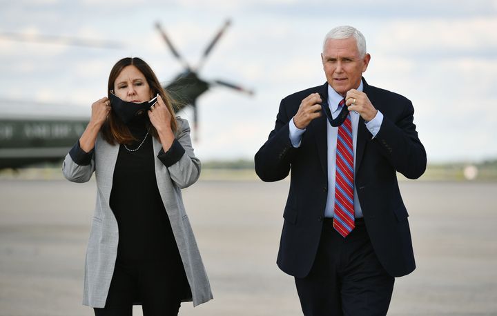 US Vice President Mike Pence (R) and his wife Karen Pence take their facemasks off as Pence approaches the media to speak at Andrews Air Force Base in Maryland on October 5, 2020 before traveling to Salt Lake City, Utah.