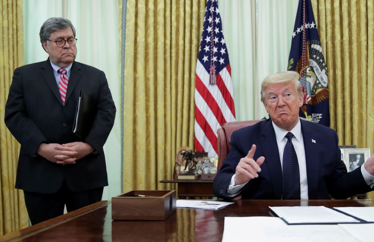 President Donald Trump speaks to reporters in the Oval Office in May as Attorney General William Barr listens.