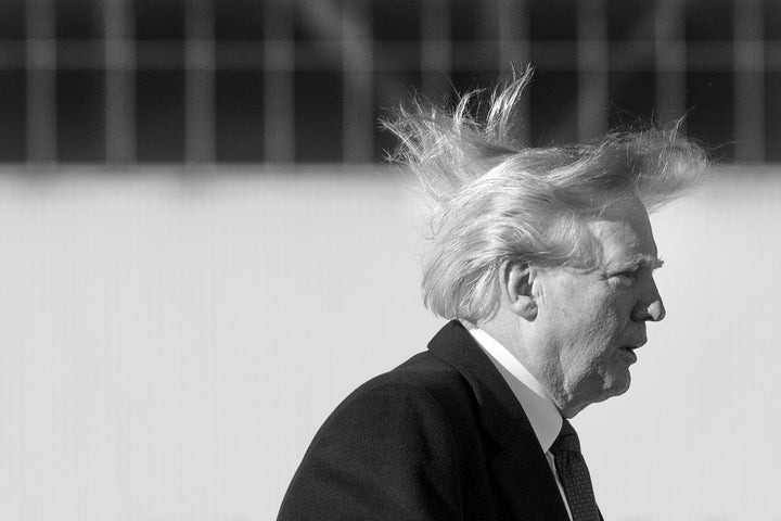 Donald Trump's hair blows in the wind as he boards Air Force One in 2017.