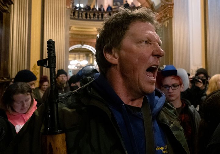 知事が出した外出禁止令の延長投票に抗議し、ミシガン州都にある議事堂で州警察に向かって叫ぶ人物（2020年4月30日）