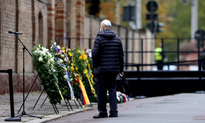 A man wearing a kippa stands in front of wreaths at the synagogue in Halle, eastern Germany, on the first anniversary of the terror attack