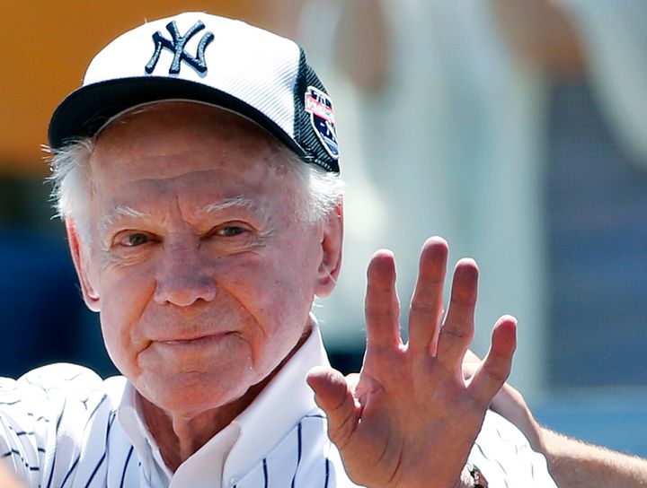 Former New York Yankees pitcher Whitey Ford waves to fans from outside the dugout at the Yankees' annual Old Timers Day baseball game in 2016 in New York.