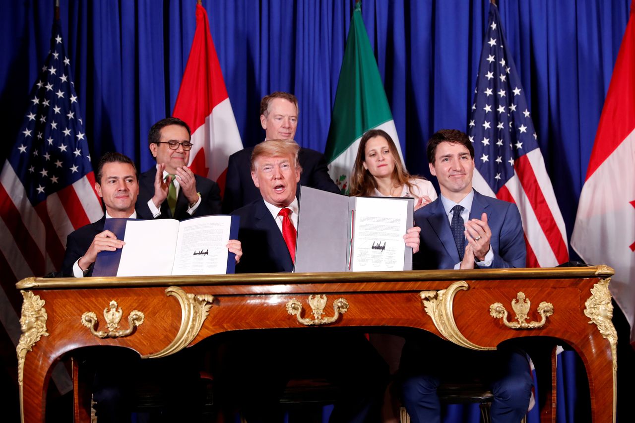 President Donald Trump signs a revised North American trade agreement alongside Canadian Prime Minister Justin Trudeau and then-Mexican President Enrique Peña Nieto in 2018.