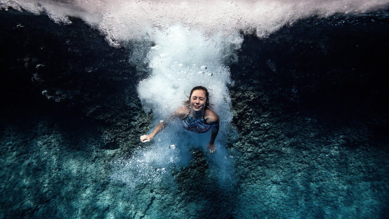 A woman dives into the clear water of "Suluada" (meaning"watery island") located 7 kilometers from another favorite spot location for deep water soloing Cape Gelidonya, in Antalya, Turkey on October 05, 2020. Deep water soloing, is a solo rock climbing, where rocks rising from the sea are climbed with no equipment except for climbing shoes and then dived into water. (Photo by Sebnem Coskun/Anadolu Agency via Getty Images)