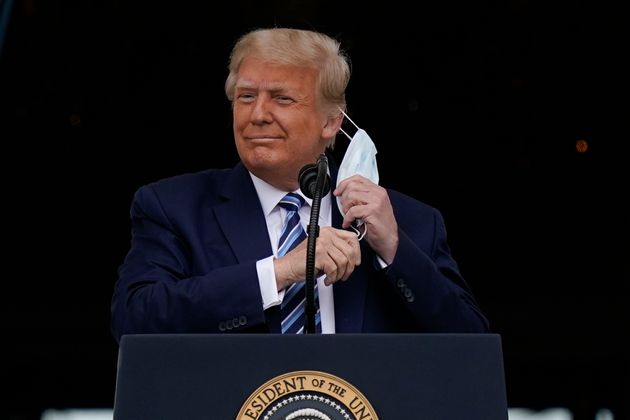 도널드 트럼프 미국 대통령이 백악관 발코니에서 지지자들을 상대로 연설을 하기에 앞서 마스크를 벗고 있다. 2020년