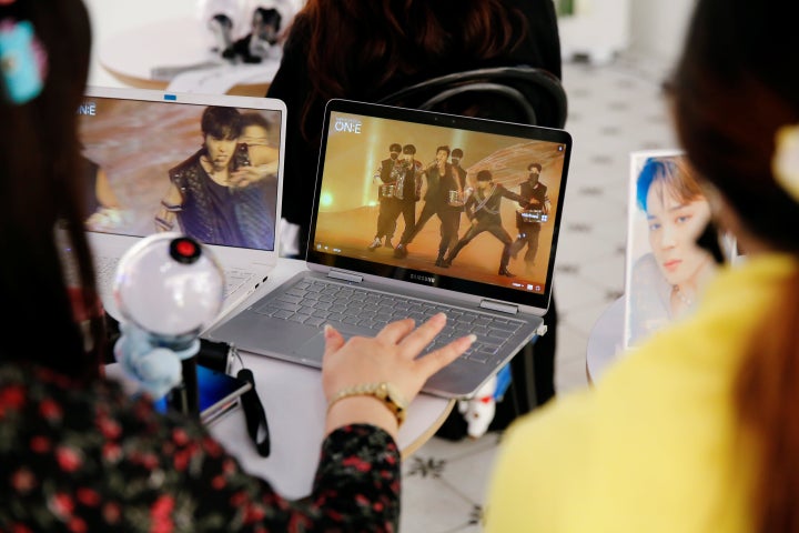 Fans watch a live streaming online concert of BTS at a cafe in Seoul, South Korea October 10, 2020.