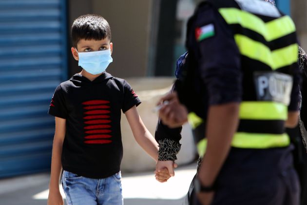A boy wearing a face mask is seen at a checkpoint during a lockdown in Baqa'a Palestinian refugee camp in Amman, Jordan, on October 1