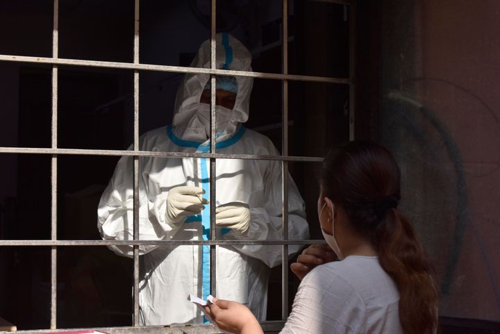 A health worker collects a swab sample to test for coronavirus, at SDM office, in Amar Colony, on October 10, 2020 in New Delhi.