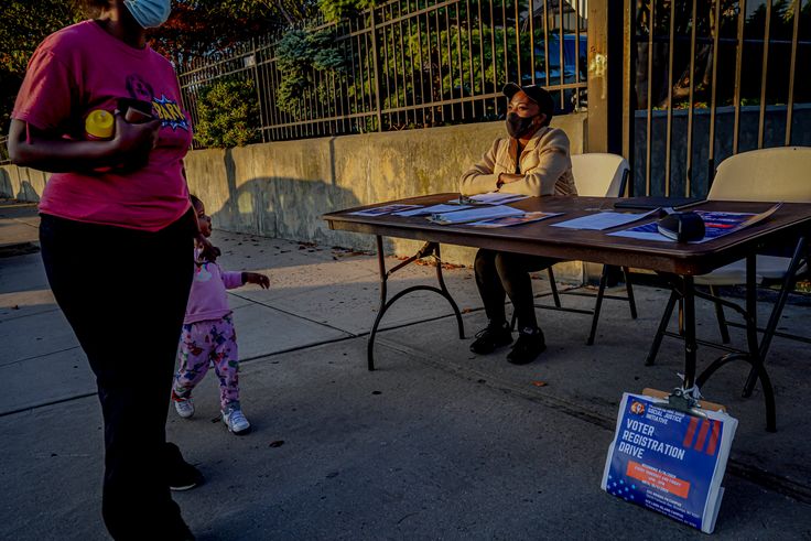 Laurae Caruth, a volunteer with Christian Cultural Center Social Justice Initiative's voter registration drive, sits at a table where she registers voters, Friday, Sept. 18, 2020, in the Brooklyn borough of New York. 