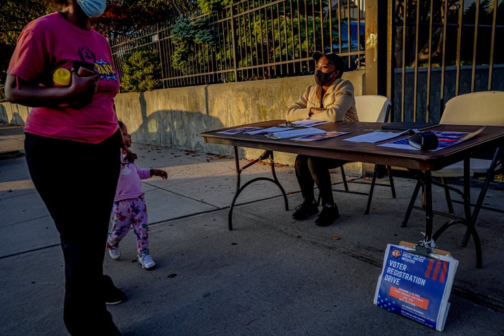 Laurae Caruth, a volunteer with Christian Cultural Center Social Justice Initiative's voter registration drive, sits at a table where she registers voters, Friday, Sept. 18, 2020, in the Brooklyn borough of New York.