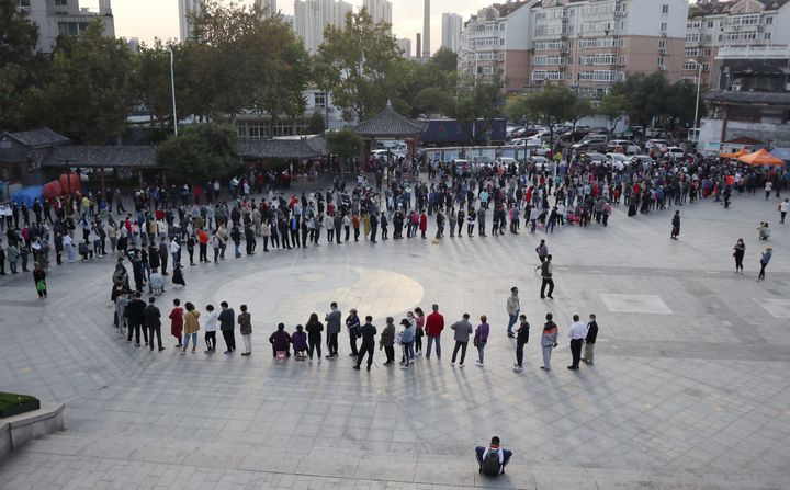 This photo taken on October 12, 2020 shows residents lining up to be tested for the COVID-19 coronavirus, as part of a mass testing program following a new coronavirus outbreak in Qingdao, in China's eastern Shandong province. 