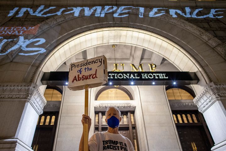 A protester stands outside the Trump International Hotel in Washington this summer.