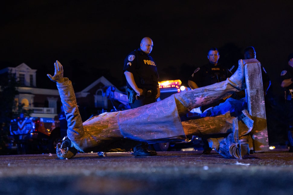 A statue of Confederate States President Jefferson Davis lies on the street after protesters pulled it...