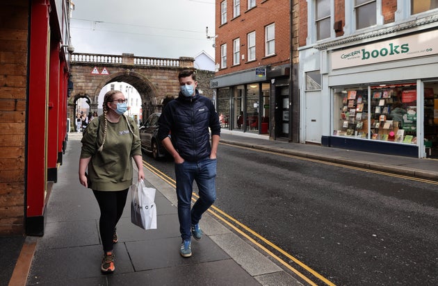 People walking along Ferryquay Street in Derry. The Stormont Executive announced a wide-ranging series of restrictions for the Derry City and Strabane Council area on Thursday in an effort to stem the spiralling Covid-19 infection numbers in the north-west of Northern Ireland. (Photo by Liam McBurney/PA Images via Getty Images)