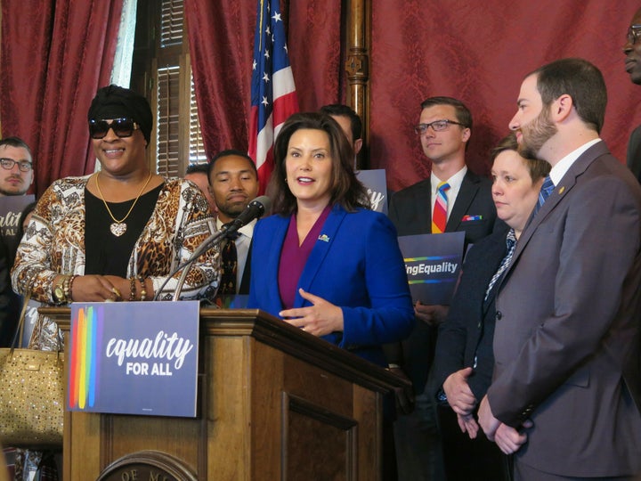 In this June 4, 2019, file photo, Michigan Gov. Gretchen Whitmer, center, joins with lawmakers and activists calling for expa