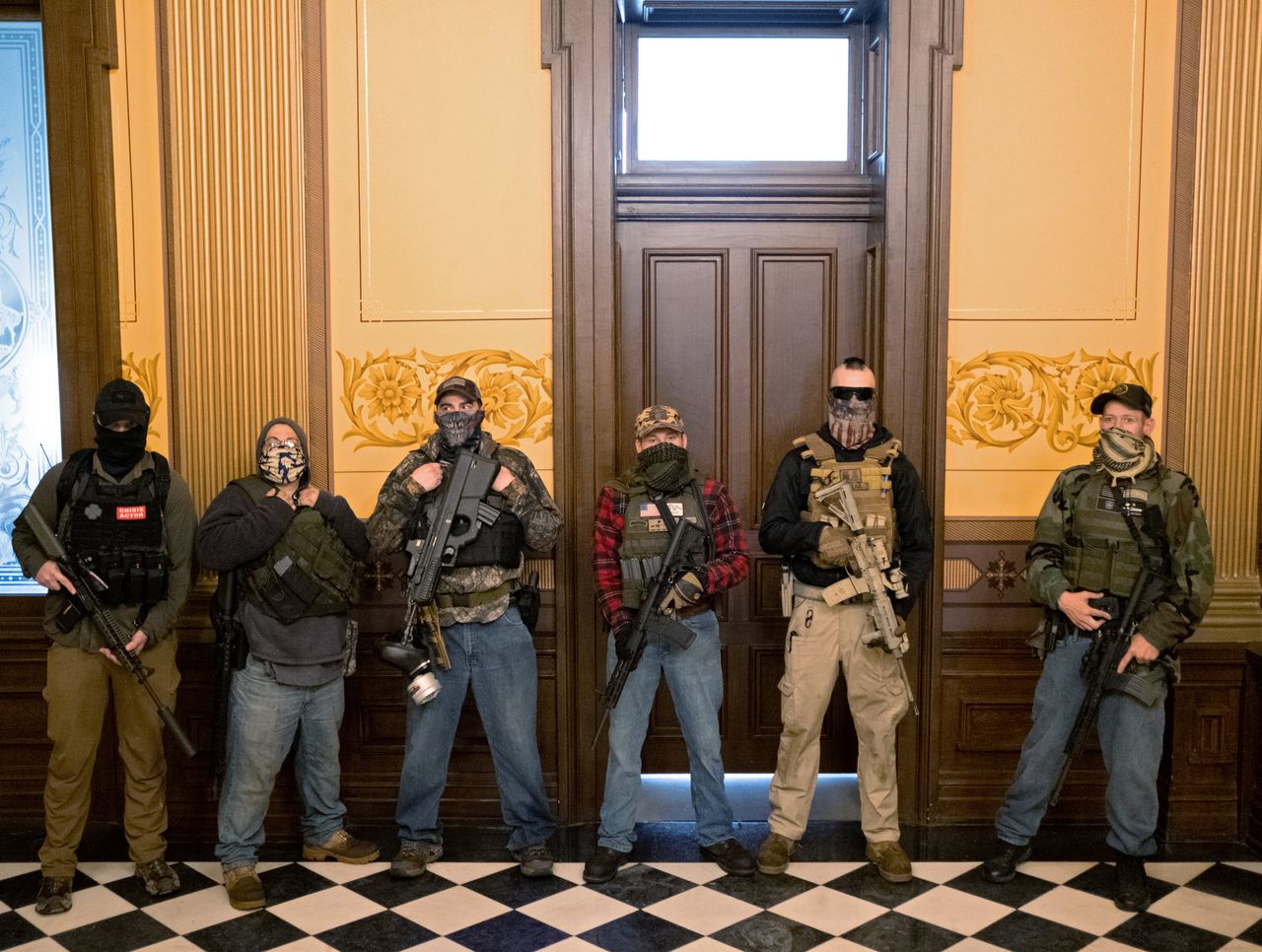 A Michigan militia group stands in front of the governor's office April 30 after protesters occupied the state Capitol in Lansing during a vote to approve the extension of Gov. Gretchen Whitmer's stay-at-home order to deal with the rise of coronavirus infections.
