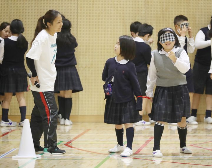 開幕半年前のイベントで、小学生に特別授業をする東京パラリンピック陸上女子走り幅跳び代表の高田千明選手（左）と伴走などを務める大森盛一さん＝2020年2月25日、東京都江東区 