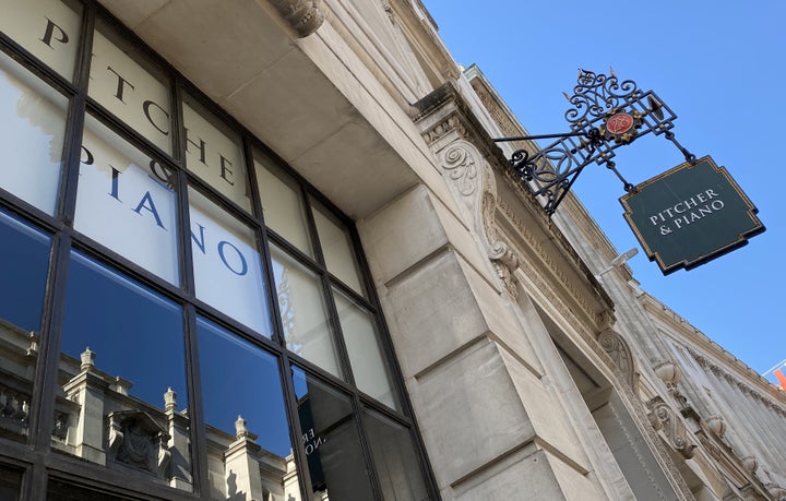 Buildings are reflected in the window of a Pitcher & Piano bar, owned by Marston's, in London.