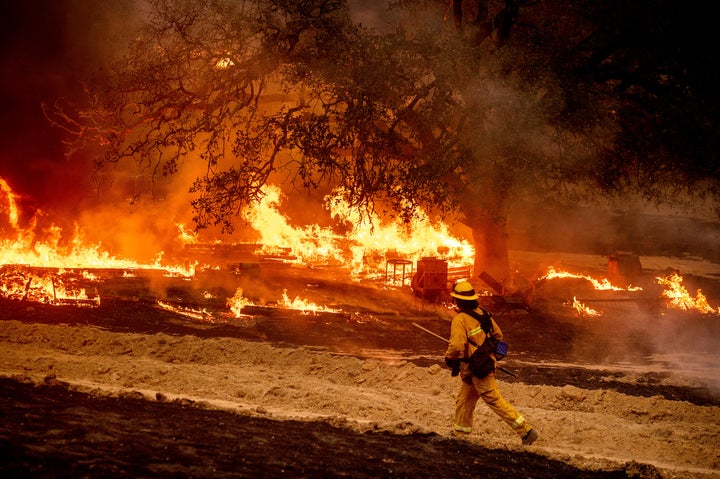 A firefighter passes flames while battling the Glass Fire in a Calistoga, Calif., vineyard on Oct. 1, 2020. 