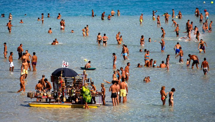 People sunbathe on the beach in the Italian town of Stintino, north west of Sardinia.