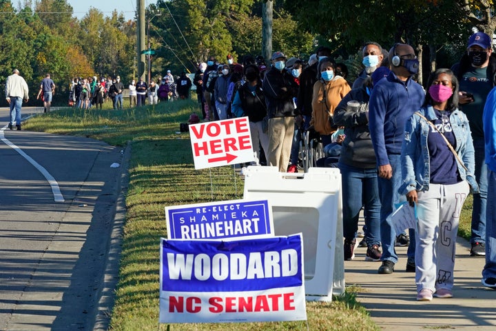 Early voters form a long line while waiting to cast their ballots at the South Regional Library polling location in Durham, North Carolina, on Oct. 15, 2020. Some waited almost three hours to vote.