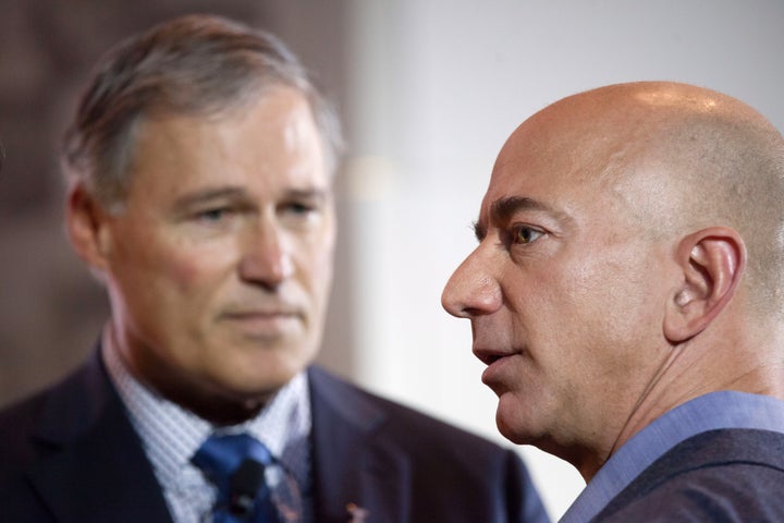 Washington Gov. Jay Inslee (D), left, joins Amazon CEO Jeff Bezos at an event in Seattle in 2013. It is unclear how much resentment of Bezos' power resonates outside of Seattle.