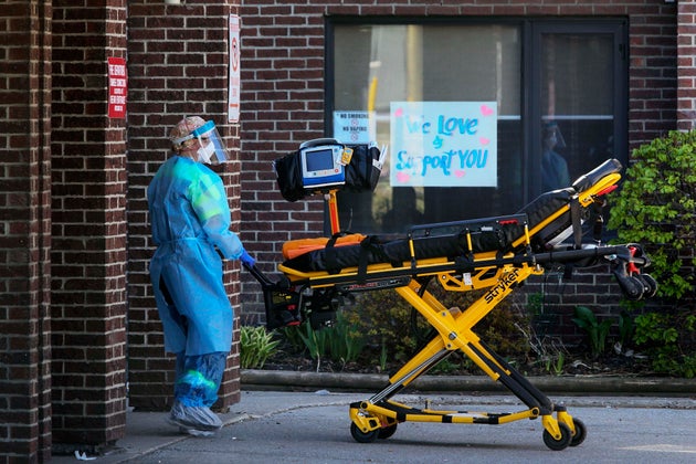 A paramedic rolls a stretcher into the Hawthorne Place Long Term Care Centre in Toronto in May. Nearly 1,900 people in long-term care have died from COVID-19 since the pandemic began.
