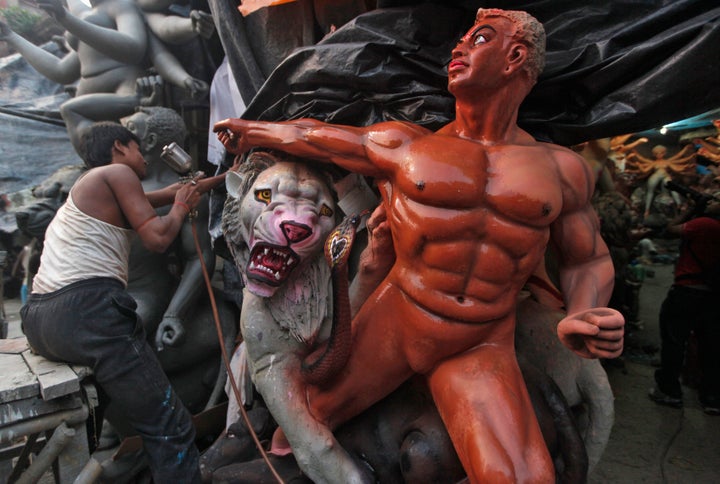 An artisan sprays paint on idols ahead of the Durga Puja festival at Machalandapur village on the outskirts of Kolkata October 6, 2012.