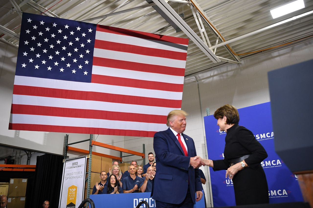 President Donald Trump greets then-Lockheed Martin CEO Marillyn Hewson at the Derco Aerospace Inc. plant in Milwaukee on July 12, 2019. Trump does not appear to be winning his political bet that increased defense spending would help his political fortunes.