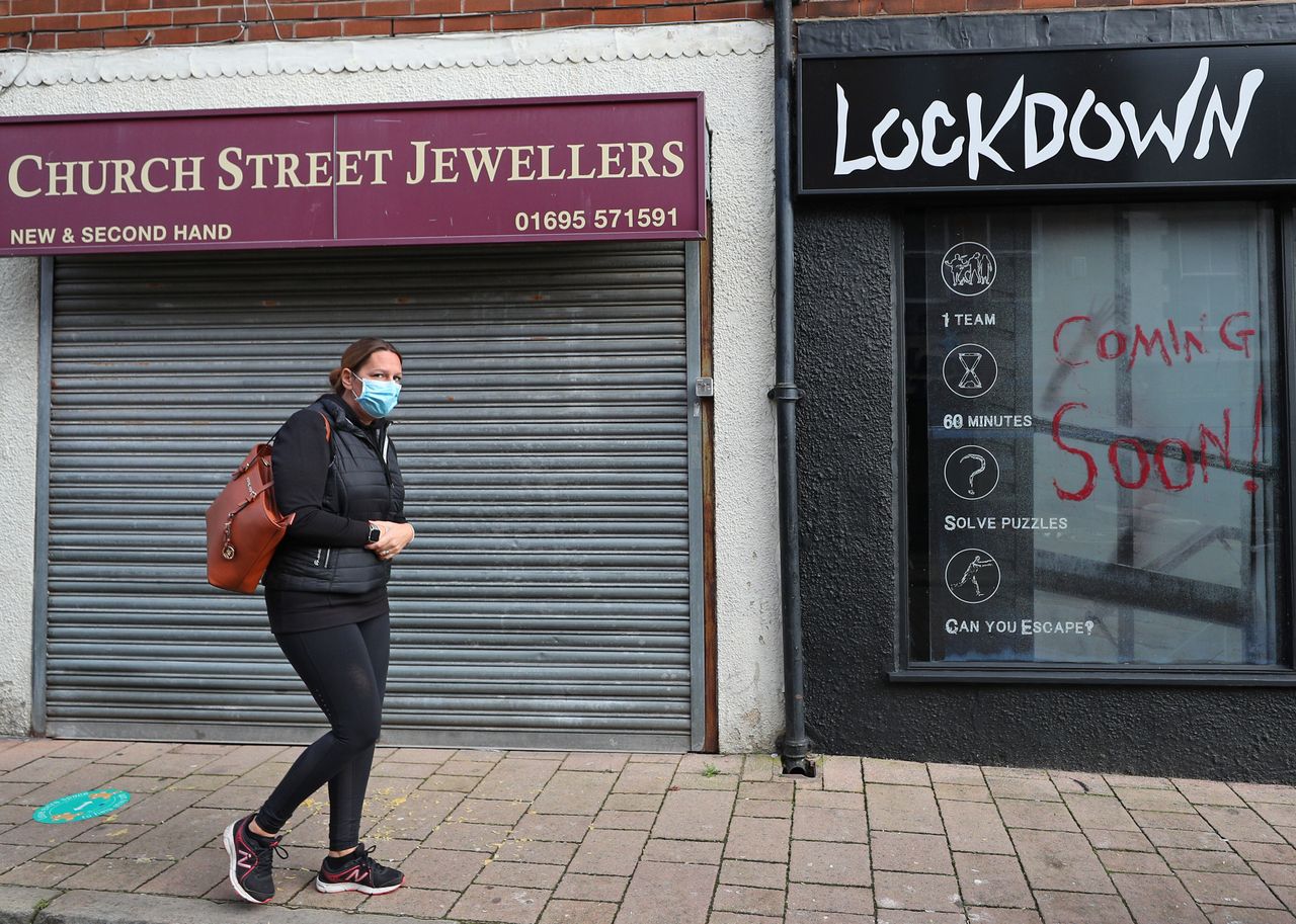 A woman walks down the street in Ormskirk, Lancashire. The Lancashire region will go into Tier 3 of lockdown restrictions after a deal was hammered out with government.
