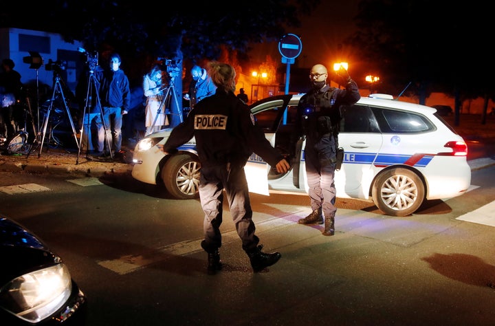 Police officers secure the area near the scene of a stabbing attack in the Paris suburb of Conflans St Honorine, France.