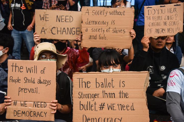 民主化を求めるメッセージが書かれたサインを掲げるデモ参加者（2020年10月16日）