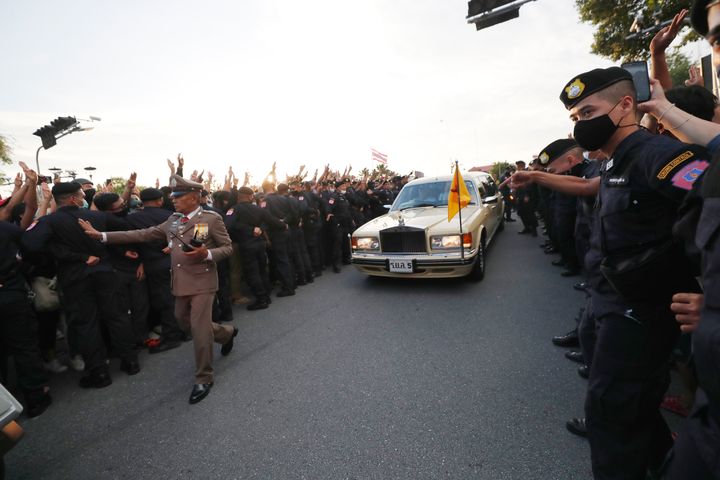 官邸前に集まった抗議デモ隊の間を車で通り抜けるタイ王室メンバー（2020年10月14日）