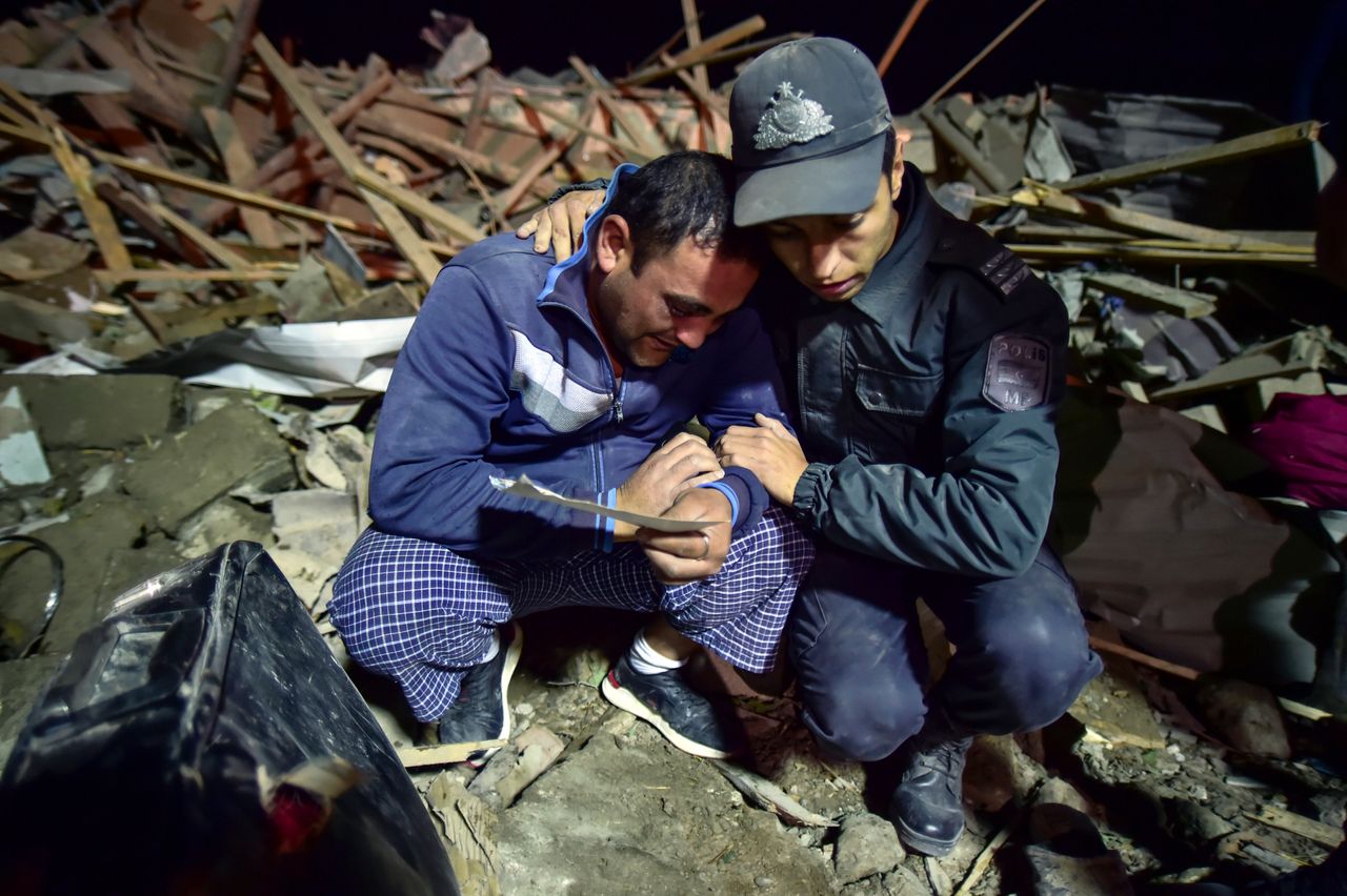 Αζέρος στρατιώτης παρηγορεί έναν άνδρας που αναζητά αγαπημένους τους στα συντρίμμια σπιτιού που βομβαρδίστηκε. 