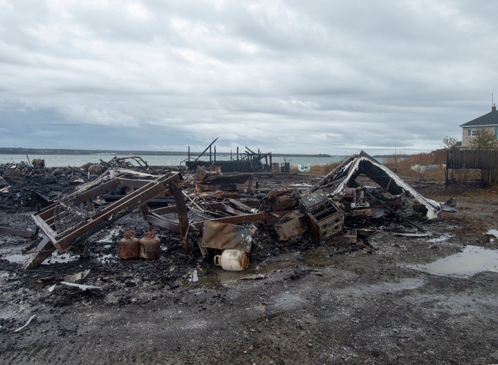 Debris from a burnt out fish plant is scattered along the shore in Middle West Pubnico, N.S. on Saturday.
