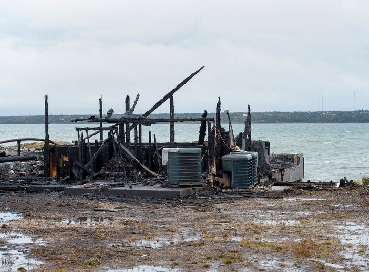 Debris from a burnt out fish plant is scattered along the shore in Middle West Pubnico, N.S. on Saturday.