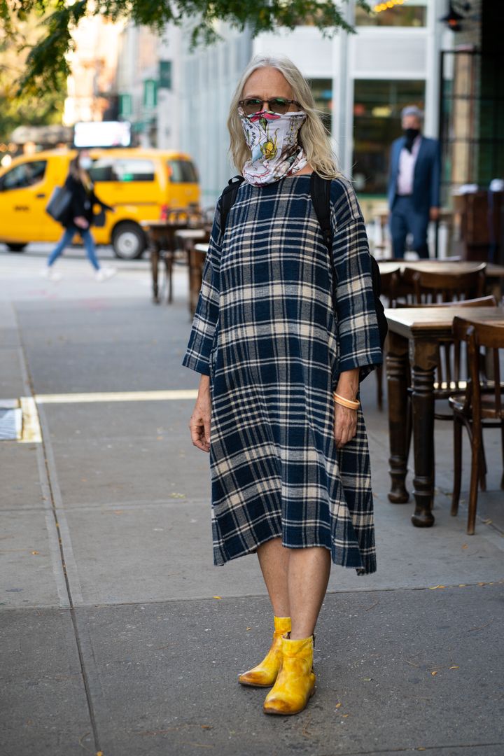 NEW YORK, NEW YORK - OCTOBER 15: Woman wears brown sunglasses, floral printed face mask and an oversized plaid dress with yellow boots in Soho on October 15, 2020 in New York City. (Photo by Jared Siskin/Getty Images)