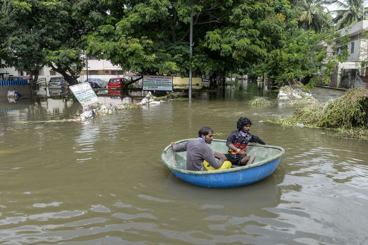 Cantonment Board workers use a boat to evacuate residents on a flooded street following heavy rains in Hyderabad on October 15, 2020. 