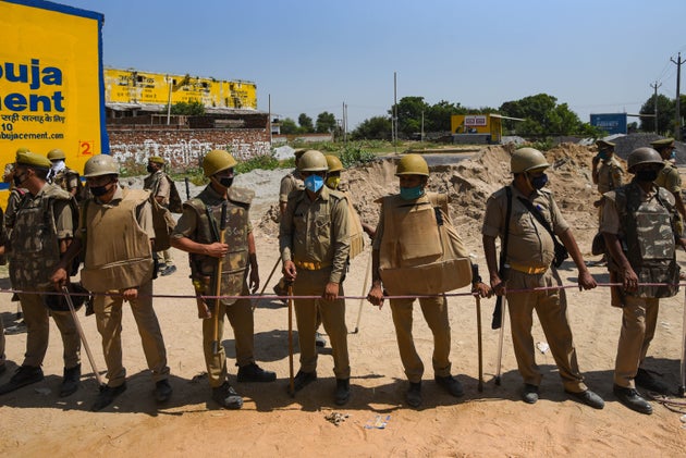 Uttar Pradesh police personnel stand guard at the entrance to Hathras village, on October 2, 2020 in...