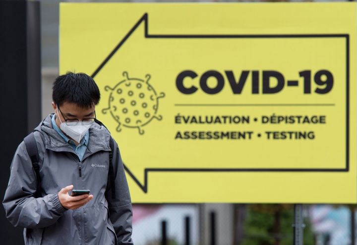 A man walks by a coronavirus testing clinic in Montreal on Oct. 16, 2020. In Canada, health officials reported 1,827 new cases Sunday.