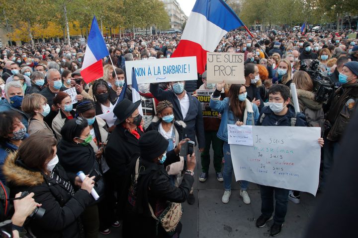 People gather on Republique square with posters reading "No to barbarity" and "I'm a teacher" for a demonstration on October 18, 2020 in Paris. 
