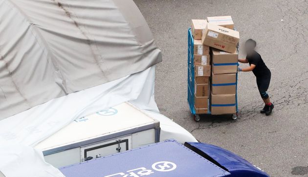 (Material photo) Staff sorting packages at a parcel distribution center in central Seoul.