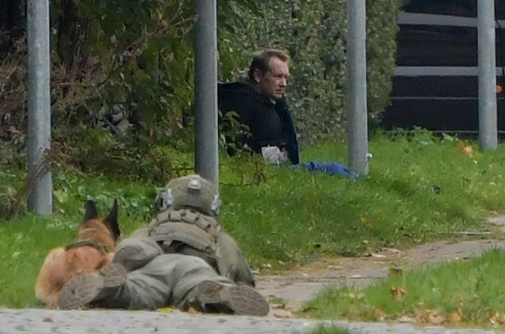 A police marksman and his dog observe the reported escapee 