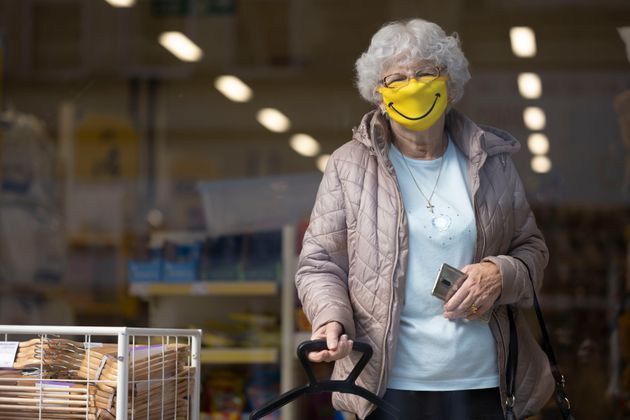 A woman smiles while wearing a novelty face mask in a shop on October 1, 2020 in Barry, Wales