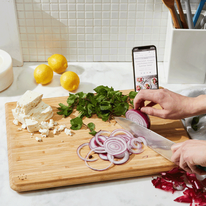 This <a href="https://fave.co/35kDSrZ" target="_blank" rel="noopener noreferrer">Food52 cutting board</a> packs a lot of design into a small package, with a phone slot on one side and a juice collection groove on the other.