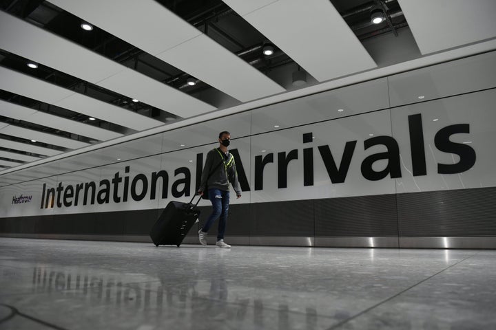 A passenger wearing a face mask as he arrives at Heathrow Airport