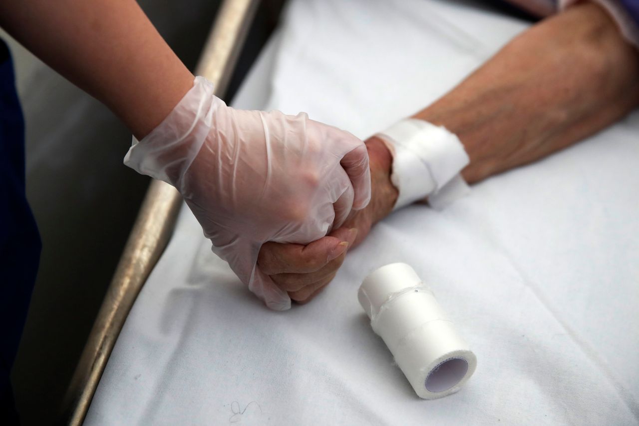 Φοίτρια ιατρικής κρατά το χέρι ασθενή στο νοσοκομείο αναφοράς "Ευαγγελισμός" (7 Μαϊου) 