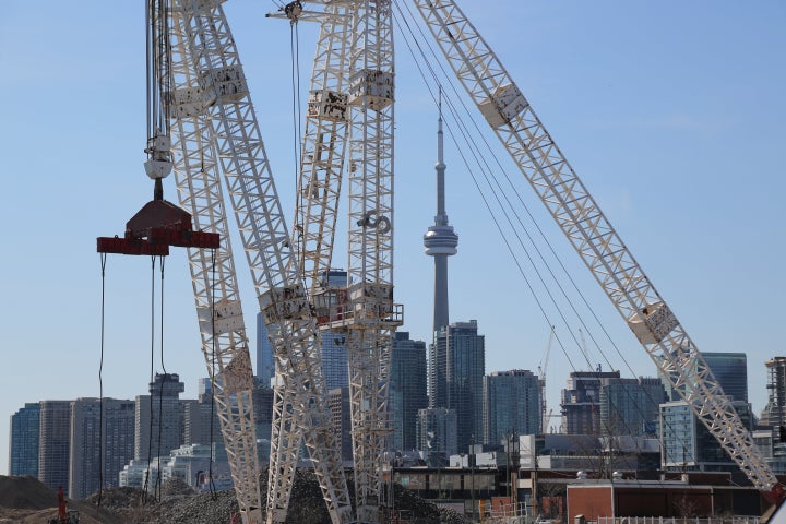 Toronto's downtown skyline and CN Tower are seen past cranes in the waterfront area, March 29, 2019. Canada's economy will recover more slowly from the COVID-19 pandemic than previously forecast.