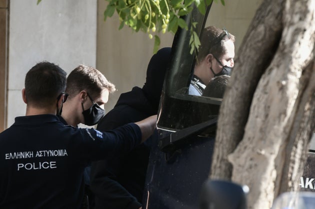 Οι καταδικασθέντες μεταφέρονται στις κλούβες από τους αστυνομικούς.